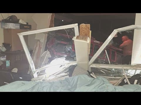 Neighbors work to clean up after a car smashes into a Fort Worth home