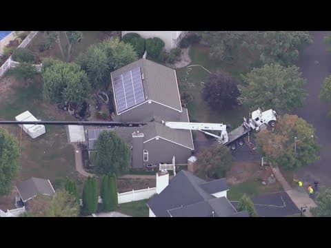 Crane falls onto home while delivering hot tub