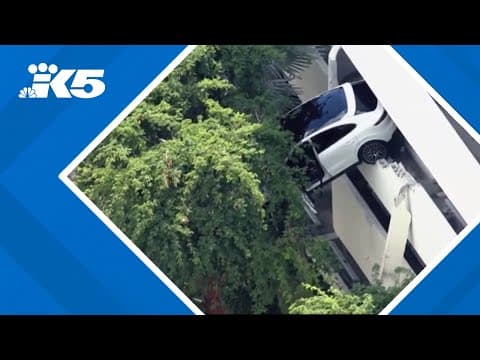 Woman rescued from car dangling off of parking garage