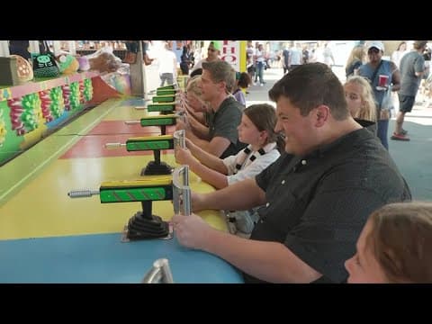 WFAA's Jason Wheeler and Jesse Hawila play water shooting game at State Fair of Texas