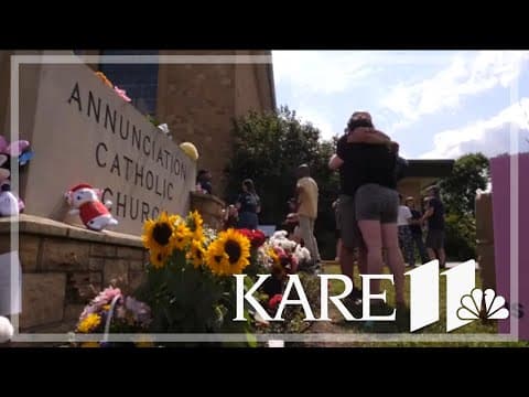Community comes together to support one another in front of Annunciation Catholic Church