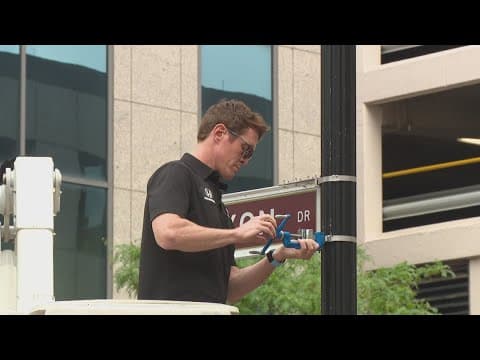 IndyCar drivers put up their street signs around downtown Indy