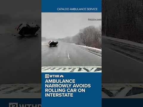Ambulance narrowly avoids rolling car on interstate