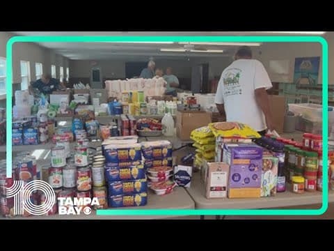 Volunteers help pass out hot meals to residents impacted by hurricanes in Cortez Fishing Village