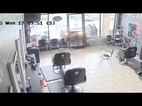 Surveillance camera captures moment car crashes into barbershop