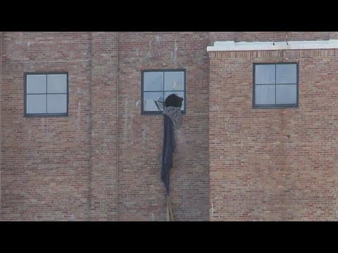 Standoff ends after armed suspect surrenders to SWAT following failed escape from apartment window