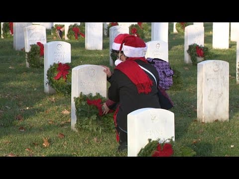 Volunteers lay wreaths on thousands of graves at Arlington National Cemetery